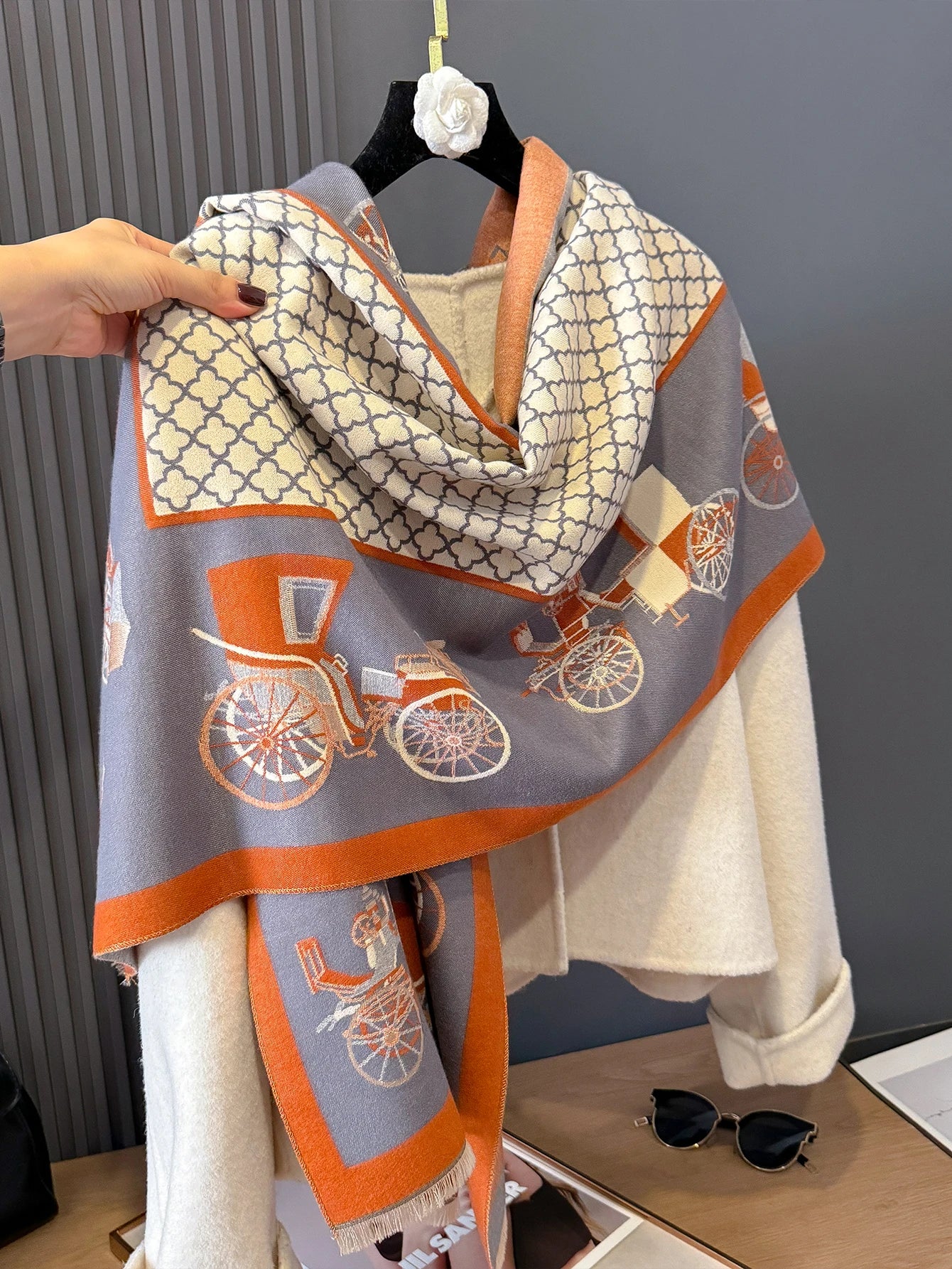 Scarf with bicycle pattern draped over a chair against a neutral background